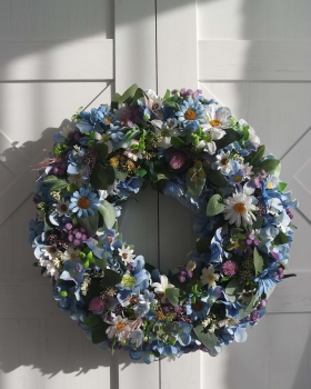 Zbliżenie drugie na sztuczny niebieski wianek Szept kwiatów z kwiatów – dekoracja na drzwi