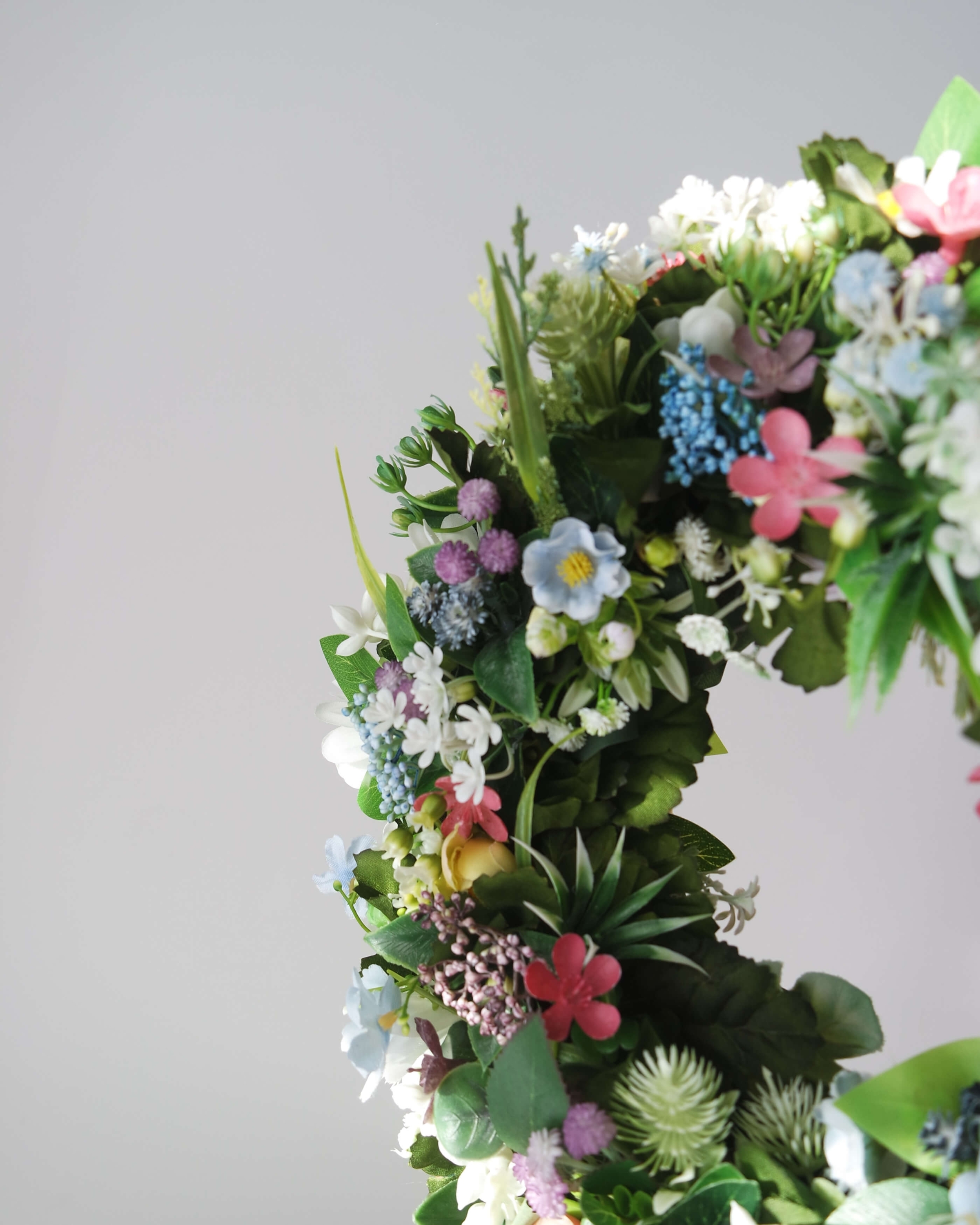 Zbliżenie czwarte na sztuczny zielony wianek Ogród marzeń z kwiatów – dekoracja na drzwi