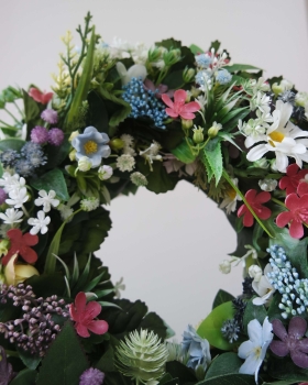 Zbliżenie na sztuczny zielony wianek Ogród marzeń z kwiatów – dekoracja na drzwi